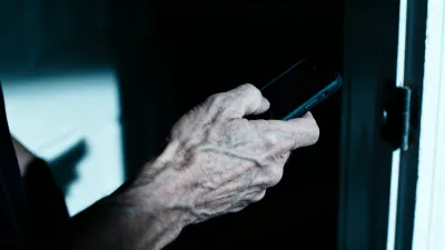 玄関先でスマホを向けられる緊迫した場面